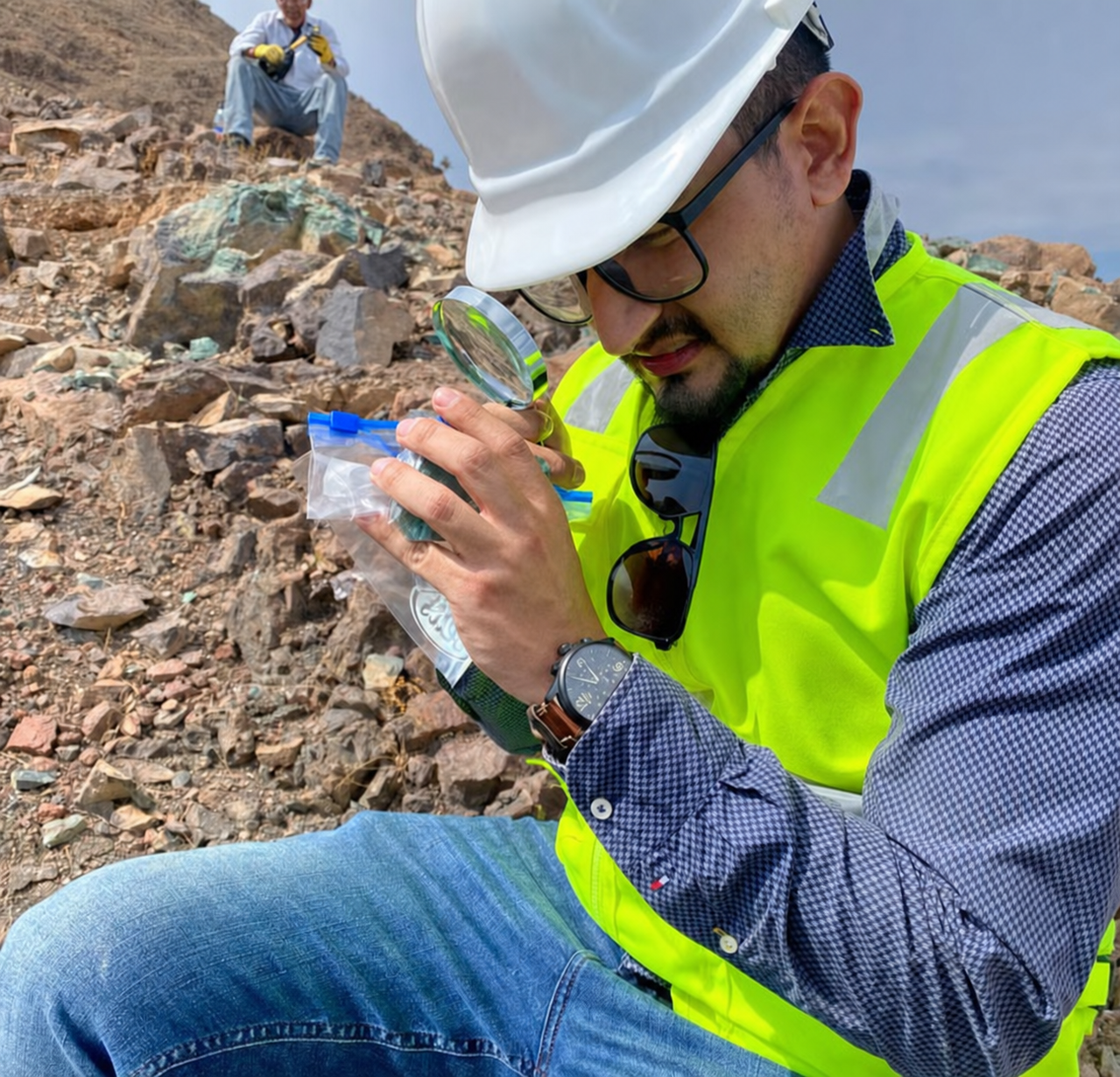 Mine due diligence specialist inspecting a mineral sample during a site visit